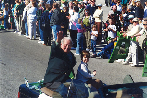 Charles Fraser in car waving at St Patrick's Day Parade